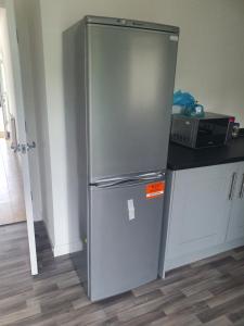 a stainless steel refrigerator in a kitchen at Immaculate 7 Bed House in Ashton-under-Lyne OL7 in Manchester