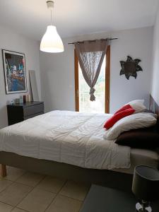 a bedroom with a large bed and a window at Villa de la croix de la main in Veyrignac