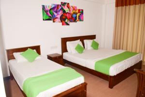 1 dormitorio con 2 camas con sábanas verdes y blancas en Olive Ivory, en Nuwara Eliya