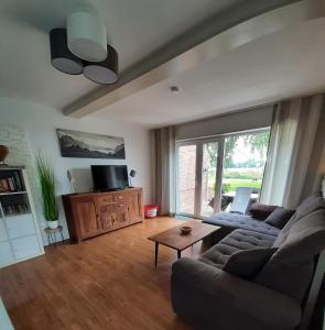 a living room with a couch and a tv at Ferienhaus Weitblick in Emden