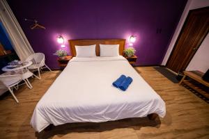 sypialnia z dużym łóżkiem z niebieskim ręcznikiem w obiekcie Thebedkolok resort w mieście Sungai Kolok