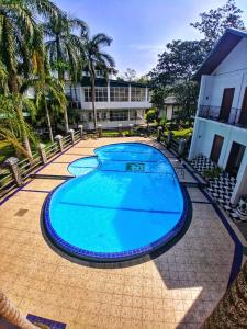 a large blue swimming pool in front of a building at Kolonne RIverside Garden Hotel in Avissawella