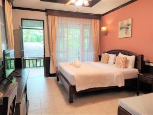 a bedroom with a bed and a television in it at Samed Villa Resort in Ko Samed