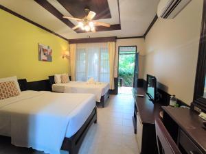 a hotel room with two beds and a television at Samed Villa Resort in Ko Samed