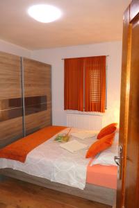 1 dormitorio con 1 cama grande con almohadas de color naranja en APARTMENT MARKO, en Senj
