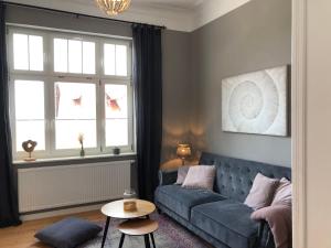 - un salon avec un canapé bleu et une table dans l'établissement Villa Hanne mit Garten, à Thale