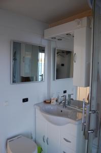 a bathroom with a sink and a toilet and a mirror at feststehendes Hausboot in Kolonie Zern
