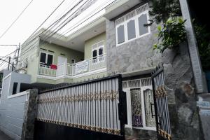 a house with a black gate and a white fence at KoolKost Syariah near Green Pramuka Square Mall - Minimal Stay 6 Nights in Jakarta