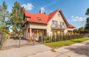 a house with a red roof and a fence at Amazing Apartment In Rowy With 2 Bedrooms in Rowy