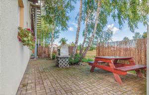 ein Picknicktisch und eine Bank auf einer gemauerten Terrasse in der Unterkunft Cozy Apartment In Rowy With Kitchen in Rowy