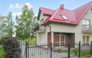 ein Haus mit rotem Dach und einem Zaun in der Unterkunft Cozy Apartment In Rowy With Kitchen in Rowy