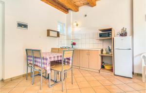 a kitchen with a table and chairs and a refrigerator at Cozy Apartment In Rowy With Kitchen in Rowy