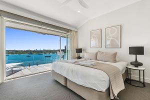 a bedroom with a large bed and a large window at Commodore 7 80 Noosa Parade in Noosa Heads