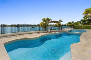 a swimming pool with a view of the water at Commodore 7 80 Noosa Parade in Noosa Heads