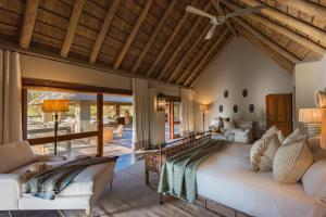 a bedroom with a large bed and a living room at Simbavati River Sands in Timbavati Game Reserve