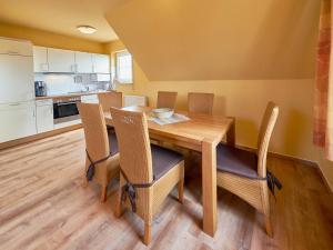 ein Esszimmer mit einem Holztisch und Stühlen in der Unterkunft Haus am See - Apt. 02 in Ostseebad Sellin