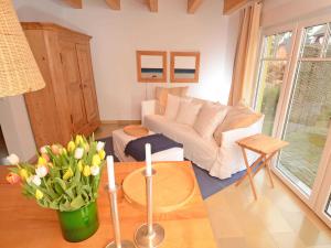 a living room with a couch and a table with flowers at Haus Baabinchen - Ferienhaus mit Kamin und Terrasse in Baabe