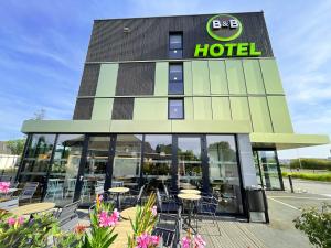 un hotel con tavoli e sedie di fronte di B&B HOTEL Compiègne a Compiègne
