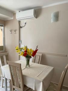 einen Esstisch mit einer Blumenvase darauf in der Unterkunft Apartman Pijavica in Bijela