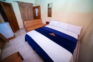 a bedroom with a large bed and a chair at Bombay Hotel in Accra