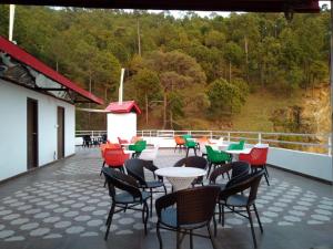 a patio with tables and chairs on a roof at Hotel Le Halcyon Kasauli in Solan