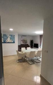 Una sala de estar con una mesa y sillas blancas. en Villa-Sana, en Vir