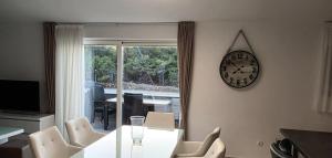 comedor con mesa y reloj en la pared en Villa-Sana, en Vir