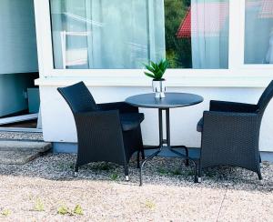 una mesa con tres sillas y una mesa con una planta. en Innerste Getaway, en Langelsheim