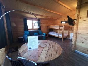 Cette chambre comprend une table en bois et un canapé. dans l'établissement Gîte Les chalets du Fliers Location de vacances à la Mer - en Chalets BERCK SUR MER, à Verton