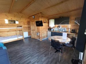 a kitchen and living room of a log cabin at Gîte Les chalets du Fliers Location de vacances à la Mer - en Chalets BERCK SUR MER in Verton