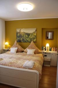 a bedroom with a large bed with yellow walls at Ferienwohnung Hildegard von Nell in Trier
