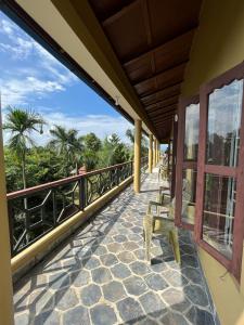 un balcón de una casa con un banco en Tiger Residency Resort, en Sauraha