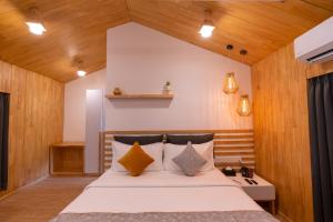 DARZA LUXURY RESORTs في كويمباتور: غرفة نوم بسرير كبير وبجدران خشبية