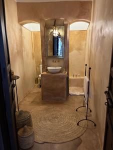 La salle de bains est pourvue d'un lavabo, d'une baignoire et d'un miroir. dans l'établissement RIAD ENNAFOURA BOUTIQUE HOTEL, à Marrakech