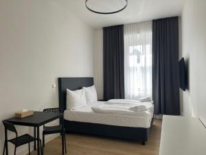 a bedroom with a bed and a table and a window at Figaro Suites in Prague