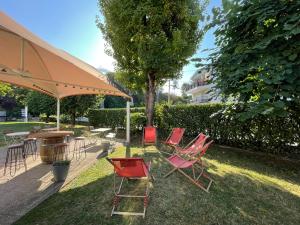 a group of chairs and a table with an umbrella at Campanile Epinay sur Orge Savigny Sur Orge in Épinay-sur-Orge