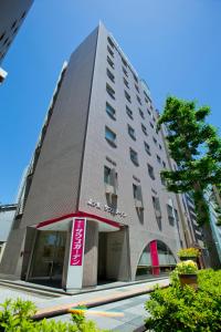 a tall building with a sign in front of it at Hotel South Garden Hamamatsu in Hamamatsu