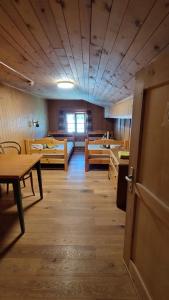pusty pokój ze stołami i krzesłami oraz drzwiami w obiekcie B&B Gassa 95 w mieście Vals