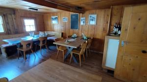 comedor con paredes de madera, mesas y sillas en B&B Gassa 95, en Vals