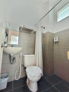 a bathroom with a toilet and a sink and a shower at The Sriwijaya Hotel - Halal Hotel in Padang