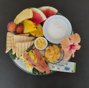 a plate of food with fruit and crackers and other foods at B&B Le Villette Las Lajas in Las Lajas