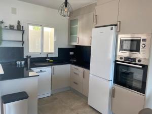 eine Küche mit weißen Schränken und einem weißen Kühlschrank in der Unterkunft Stark - AzulenaCalpe in Calpe