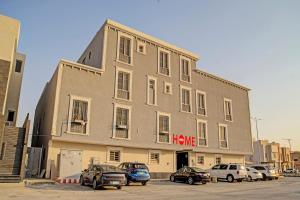 un gran edificio con coches estacionados frente a él en Super OYO 629 Home Lux Suite, en Riad