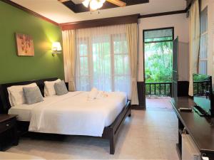 a bedroom with a large bed and a large window at Samed Villa Resort in Ko Samed