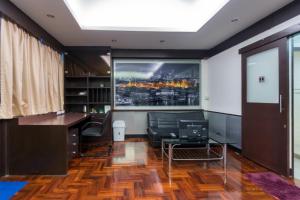an office with a desk and a large window at Flourish Apartments Sukhumvit 39 in Bangkok