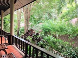 a porch with benches and trees and bushes at Samed Villa Resort in Ko Samed