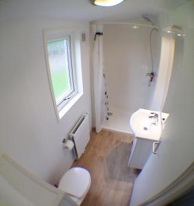a bathroom with a sink and a toilet and a window at MADRID - Studio mit Sandstrand & Seeblick nahe Rhein-Main und Spessart in Kahl am Main