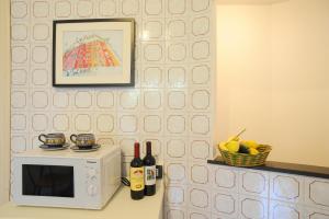 a microwave on a counter with bottles of wine at Sivori Apartment in Bonassola