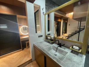 une salle de bain avec un lavabo et un grand miroir dans l'établissement SunwayPyramid USJ Jacuzzi HomeCinema PS Game 16Pax, à Subang Jaya 19 autres photos