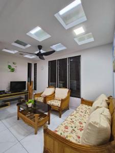 uma sala de estar com um sofá e uma televisão em Family 15 Pax Corner Lot House / Free WiFi em Subang Jaya